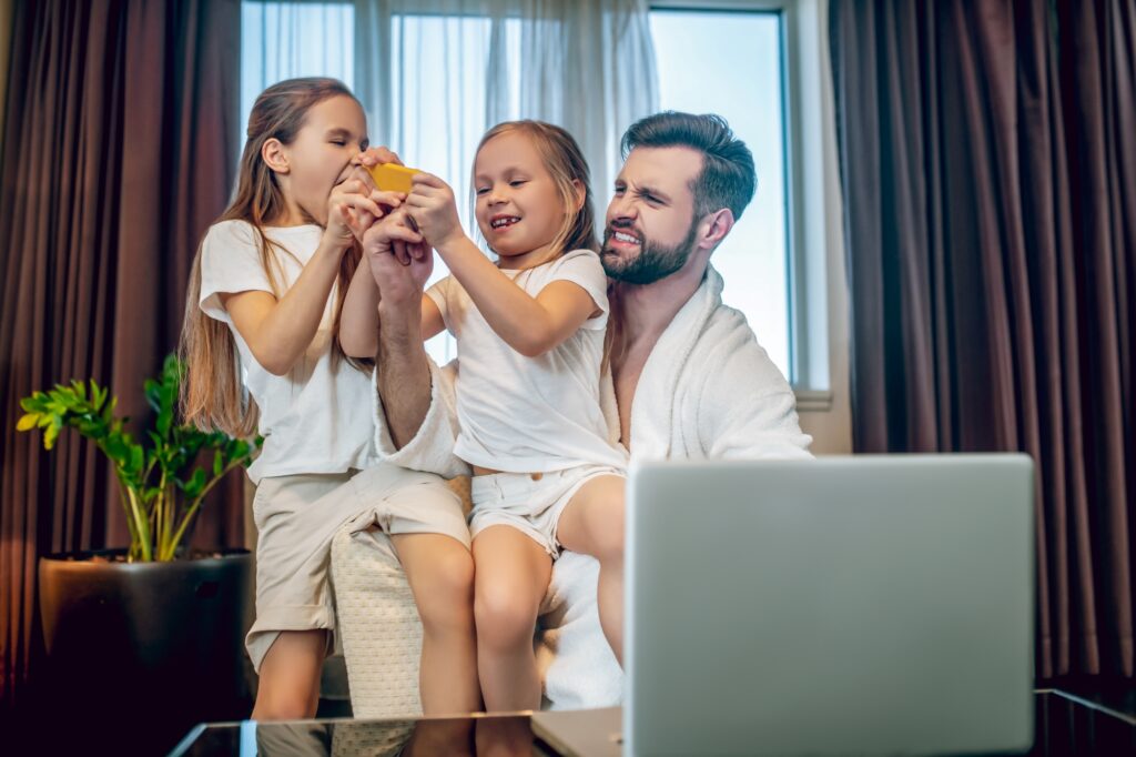 A father and daughters in a hotel room before moving into their new house